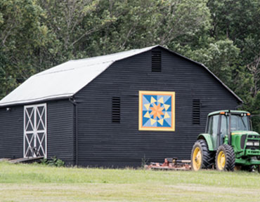 black barn with quilt