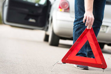 Someone placing emergency triangle on road