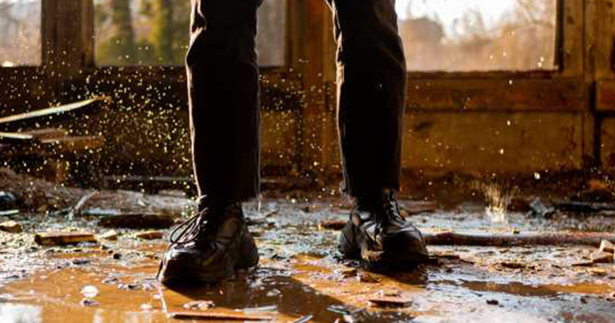 Person standing in doorway of flooded home